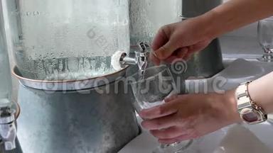 女人从饮水机里拿一杯水的动作